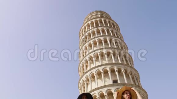 意大利比萨两个穿着睡衣的年轻女子走在比萨斜塔旁视频的预览图