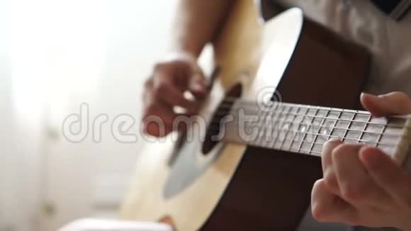 男人手指捏着吉他的琴弦视频的预览图