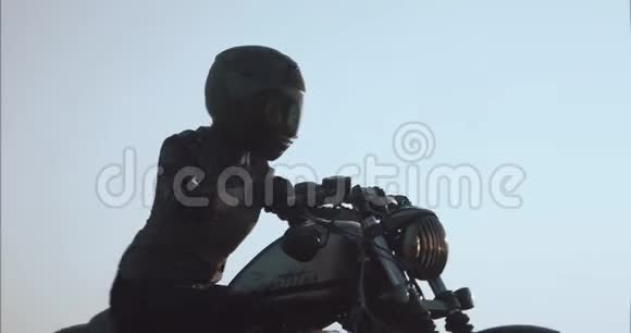 女孩驾驶摩托车顶着天空在碎石路侧景视频的预览图