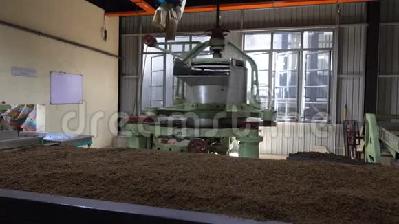 在一家茶厂里磨碎茶叶的机器的工作视频的预览图