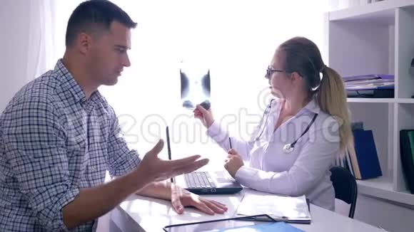 医生与病人在诊所考虑x线在医疗办公室的预约视频的预览图