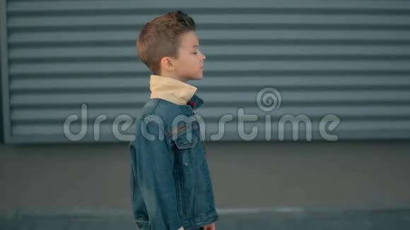 独自一人的小男孩走在街上思考一个严肃悲伤的男孩的脸视频的预览图