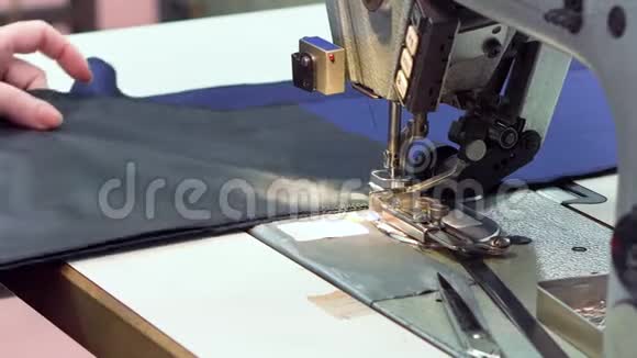 女裁缝把布料缝在纺织生产线上关上缝纫机视频的预览图