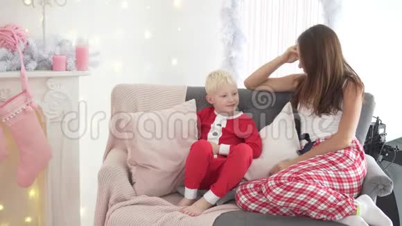 妈妈和儿子坐在圣诞树上视频的预览图