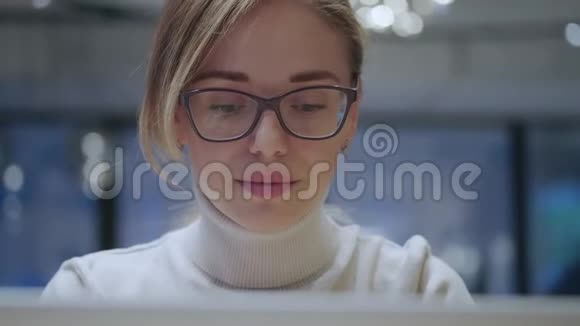 一个戴眼镜的女孩在笔记本电脑上的特写镜头视频的预览图