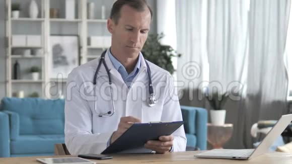 高级医生阅读病人医疗文件视频的预览图