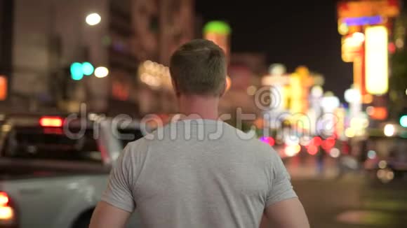 夜间拍摄唐人街街道照片的年轻游客的后景视频的预览图