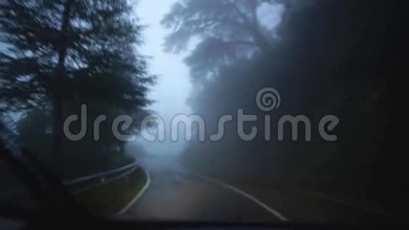 在旅途中从驾车沿着路边看多雨的雾蒙蒙的道路风景如画塞浦路斯慢动作视频的预览图