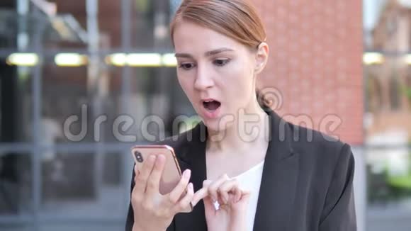 户外年轻女商人在使用智能手机时因失守视频的预览图