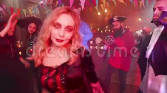 穿着黑色性感服装的女妖在万圣节派对上和她可怕的朋友跳舞视频的预览图