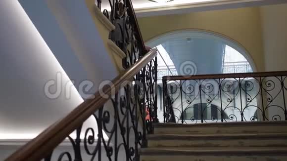 女孩在一座豪华的老式建筑里走下楼梯视频的预览图