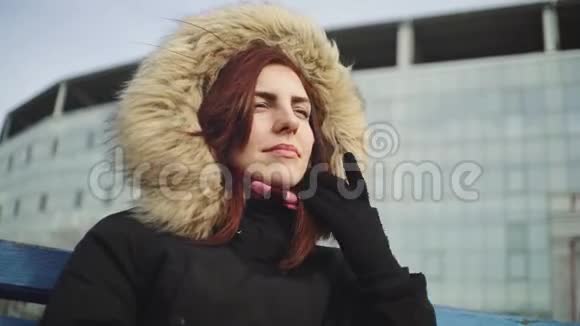 肖像微笑的年轻女子拿着一杯茶或咖啡喝着寒冷阳光下的户外视频的预览图