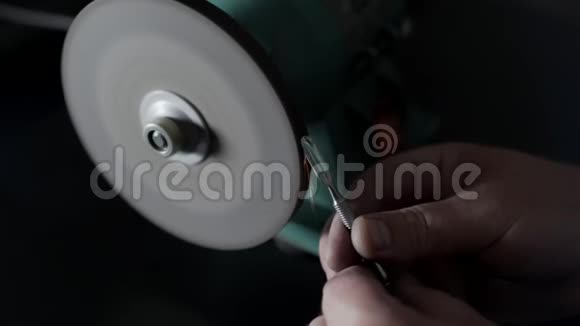 特写镜头工人在磨石上磨指甲在慢镜头中闪耀视频的预览图