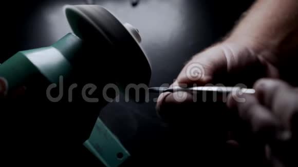 特写镜头工人在磨石上磨指甲在慢镜头中闪耀视频的预览图