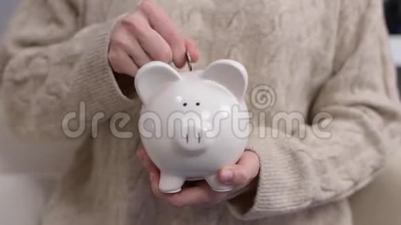 女人赚钱存钱女人把硬币放进储蓄罐视频的预览图