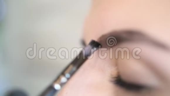 美容大师正在为年轻的女性客户在眉毛上涂上黑色的化妆品4克格拉摩穆阿慢动作视频的预览图