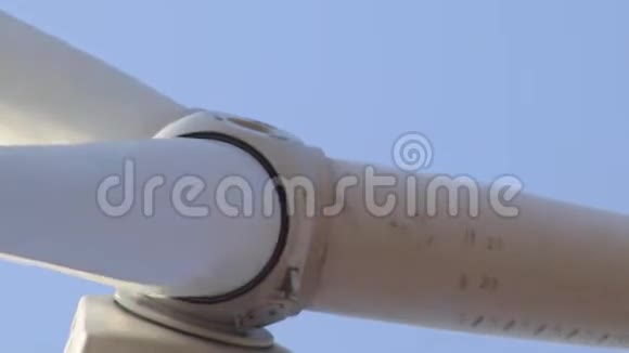 靠近一个白色转子的风力发电机的正面背景上有一个晴朗的蓝天视频的预览图