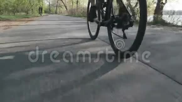 骑自行车的人骑着自行车跟着射击自行车轮旋转在城市公园里骑自行车视频的预览图