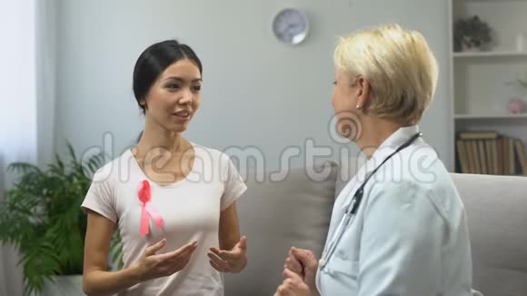 女志愿者穿着粉红色丝带与医生交谈诊所提供信息视频的预览图