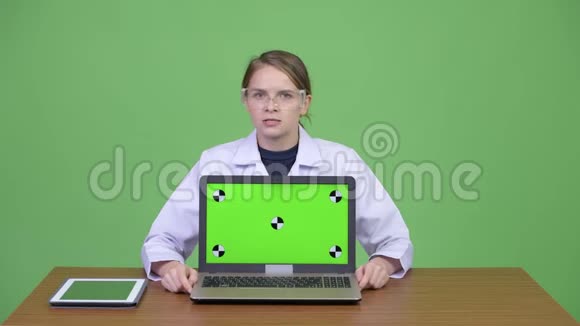 年轻漂亮的女医生戴着防护眼镜带着笔记本电脑视频的预览图