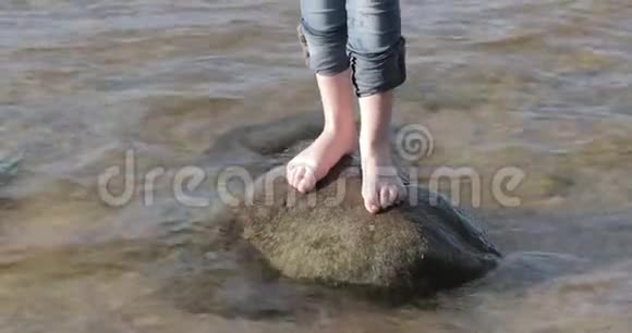 光着脚在水边的石头上视频的预览图