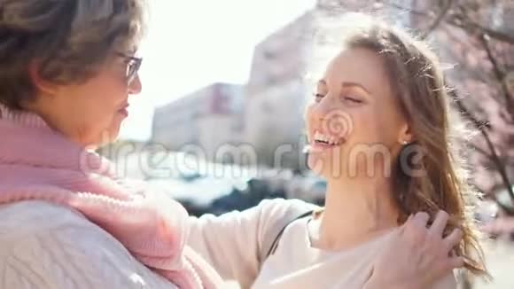 两个成年女人拥抱和大笑春季户外肖像画视频的预览图
