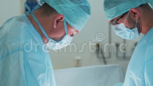 手术期间穿无菌衣服和口罩的医生团队慢动作视频的预览图