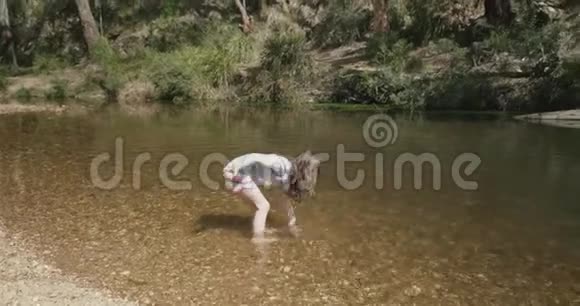 小女孩在河里玩耍把水变成了她头上的拱门视频的预览图