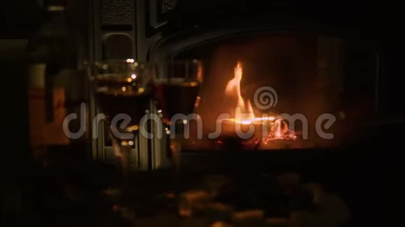 在燃烧的壁炉旁提供餐和葡萄酒的桌子视频的预览图