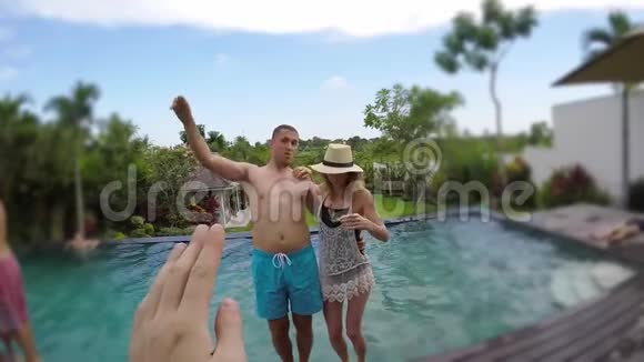 年轻可爱的夫妇在热带度假别墅拍照并掉进游泳池视频的预览图
