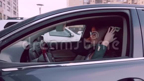 汽车女士在镜子后视以检查化妆在汽车上停在车里的女人视频的预览图