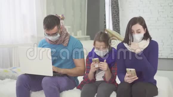 流行病的概念一家人生病咳嗽坐在家里戴着医疗面具视频的预览图