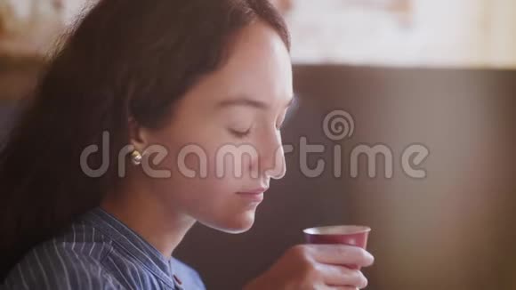 从中国红杯喝茶的女性侧景视频的预览图