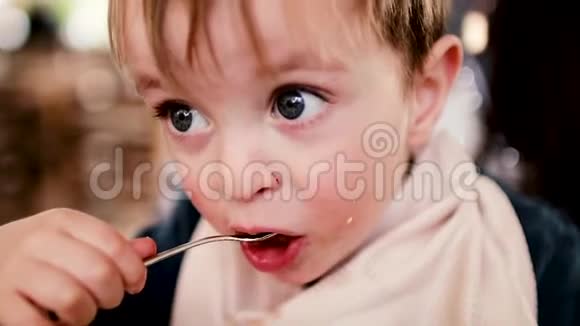 妈妈用婴儿勺子喂婴儿食物慢动作白色视频的预览图