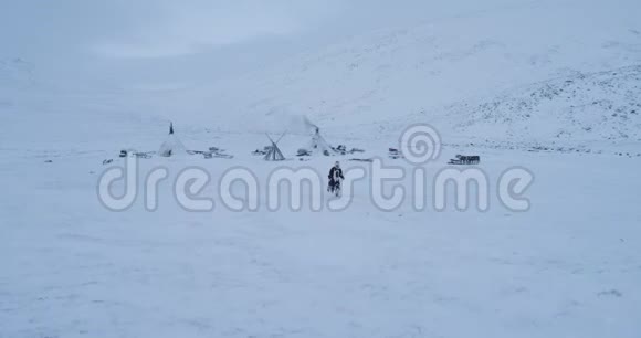 惊人的捕捉视频奔跑的人在西伯利亚中部一个大营地蒙古包和驯鹿周围4k视频的预览图