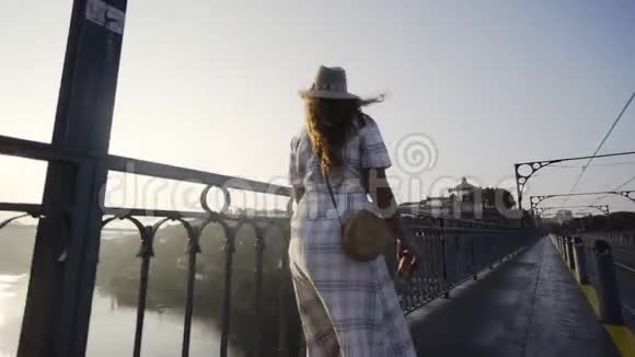快乐的年轻女子走在高高的桥上视频的预览图