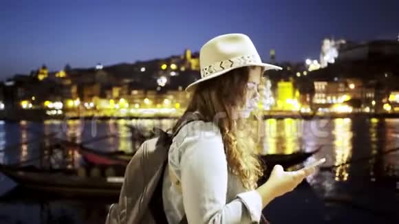 戴帽子的女士背包和智能手机放在堤岸上视频的预览图