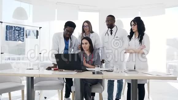 医院里有五个年轻医生一起用笔记本电脑视频的预览图