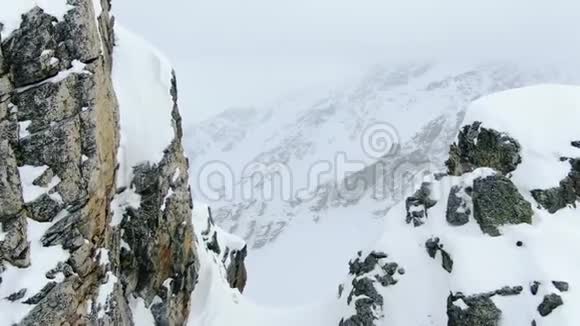 巨大的山顶和覆盖着新鲜粉末雪的小山空中射击4k视频的预览图