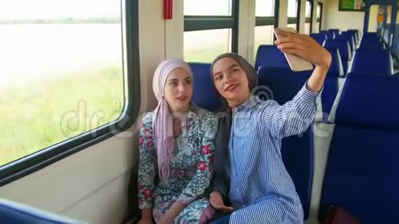 两个年轻的穆斯林女人戴着头巾用电话自拍视频的预览图