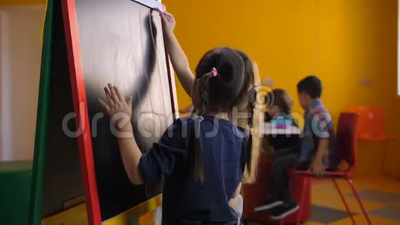多民族女孩在黑板上画画视频的预览图