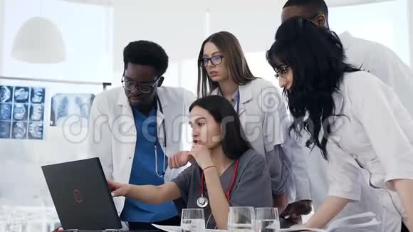 一群医生在会议室里一起使用笔记本电脑视频的预览图