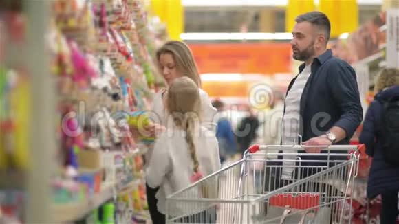 美丽的夫妇和他们的女儿在超市购物时很开心视频的预览图