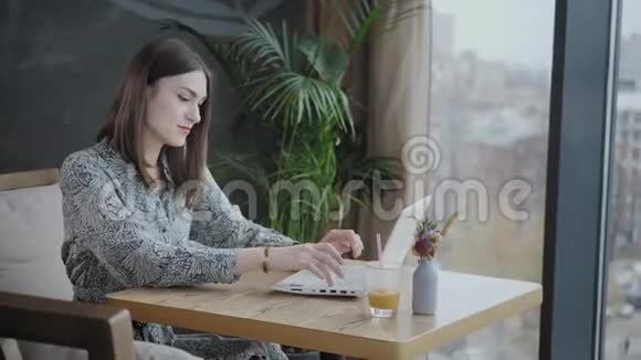 年轻女子在键盘上打字聊天写博客自由职业者在现代合作中的上网本工作成功人士视频的预览图