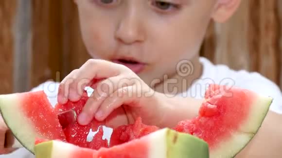 一个孩子用刀把一块西瓜切下来吃了特写镜头视频的预览图