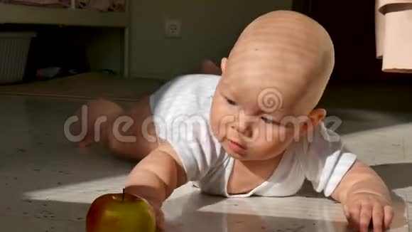 一个六个月大的男孩和苹果躺在地上视频的预览图