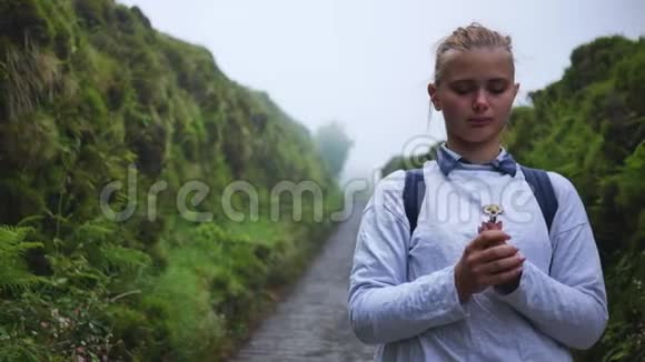 小女孩站在雾中的森林里神秘地看上去视频的预览图