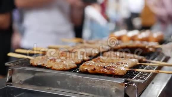 男人在烤架上烤沙第马来西亚印度尼西亚和泰国的流行食品街头美食4k视频的预览图