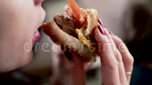那个女孩有一个芝士汉堡吃汉堡特写视频的预览图