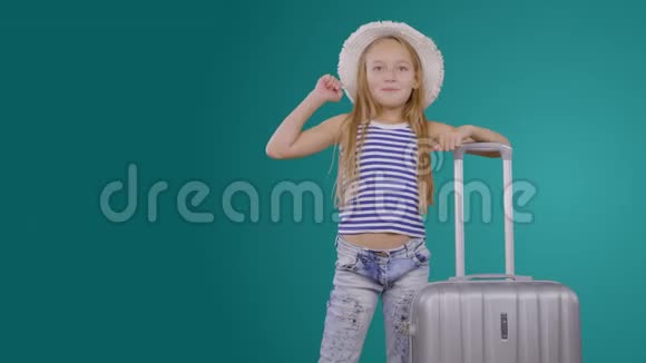 开朗的女孩旅行博主带着旅行箱邀请绿色背景旅行视频的预览图